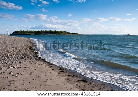 The ocean meets the shore in the late afternoon in landscape orientation