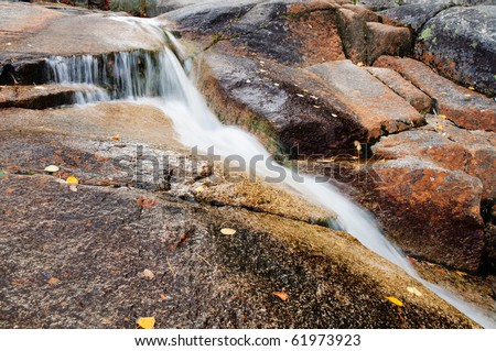An alpine waterfall runs over granite in New England