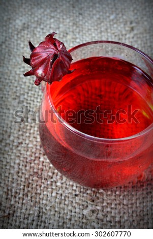 Roselle juice drink. Hibiscus sabdariffa or roselle fruits juice. on sack textured background
