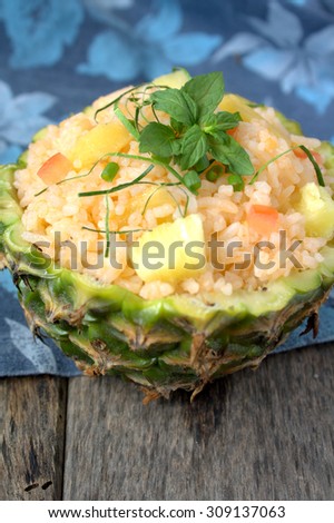 Pineapple fried rice with tomato served in bowl made of pineapple fruit