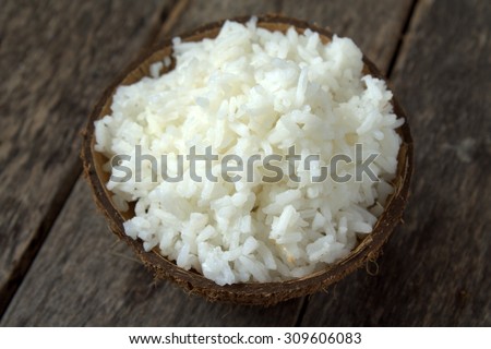 Cooked rice served in coconut shell . Rice is the seed of grass species Oryza sativa. As a cereal grain, most widely consumed staple food of world's human population especially in Asia.