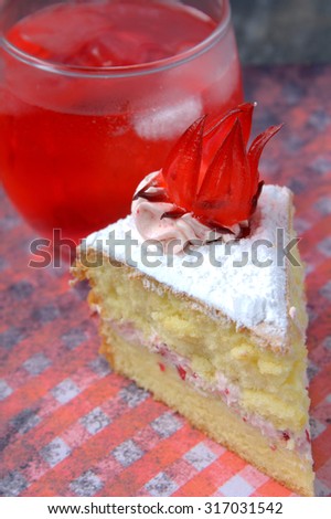 Sponge Cake with roselle or rosella jam in the middle and roselle fruit on top of rosella cream flavour. served with refreshing roselle juice.