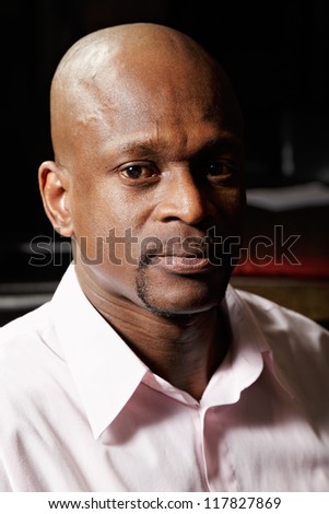 Portrait of african man in pink shirt looking to camera