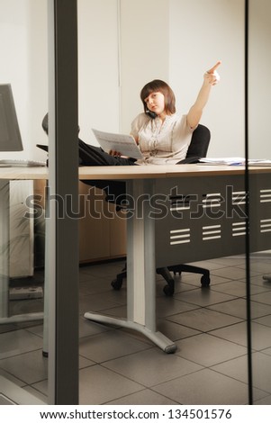 Brunette businesswoman gesturing go out while sitting in chair with papers