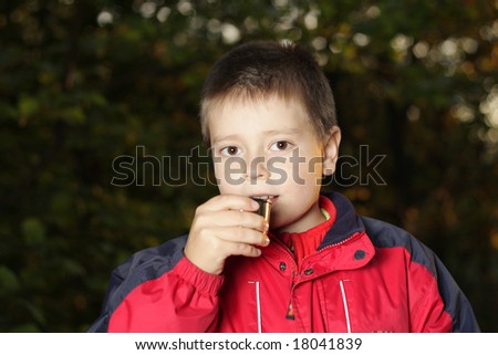 Boy standing and drinking tea from thermos cup