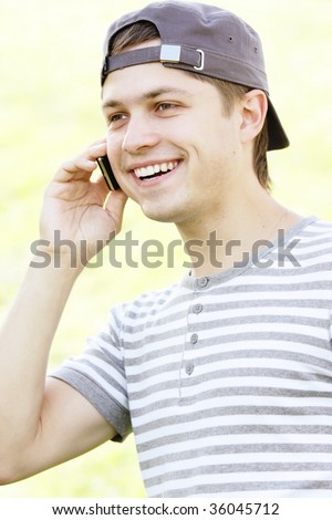Smiling guy with phone at ear outdoor photo