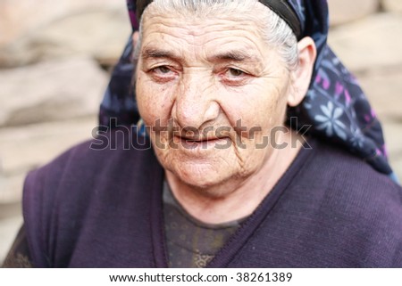 Elderly woman with piercing gaze closeup outdoor photo