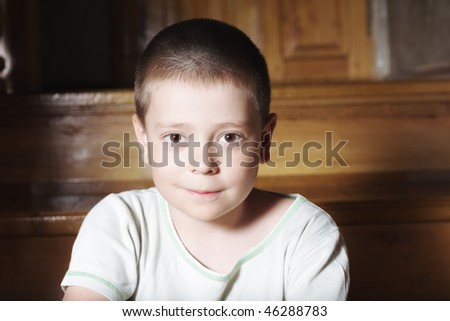 Little cute boy in shirt sitting on steps closeup photo