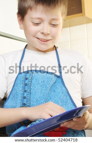 Smiling boy in white shirt and apron rubbing plate