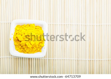 Saffron spice in white ceramic dish on straw mat above view