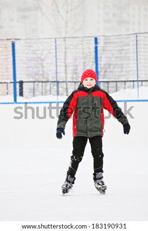 Smiling boy standing on the ice rink outdoors