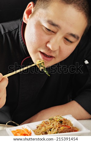 Guy wearing black robe enjoying glass noodles
