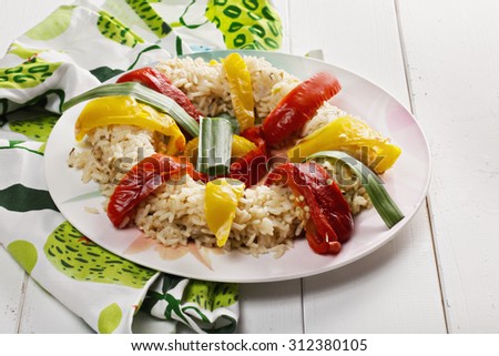 Risotto with oven-baked bell peppers on a white wooden tabletop