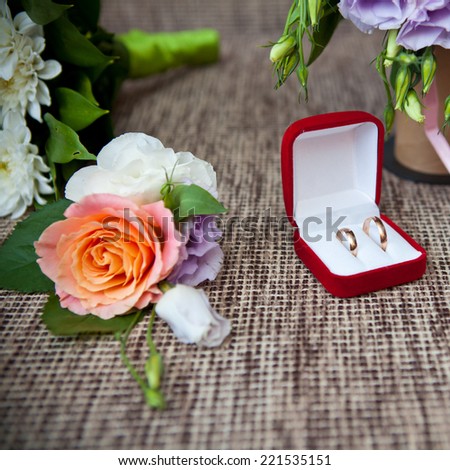 Wedding rings in a box and boutonniere, shallow depth of field