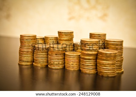stack of coins on a black wooden background, shallow depth of field