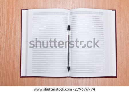 Open Address Book on a wooden background and ballpoint pen