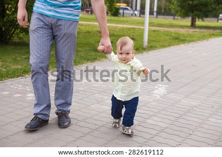 father and son walking hand in park