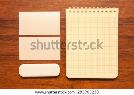 blank notepad, business cards and flash card on a wooden background. Mock-up for branding identity