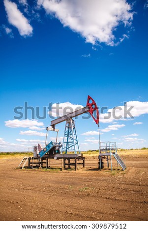Oil pump in the open air, on a background of the cloudy sky