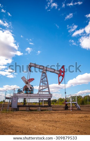 Oil pump in the open air, on a background of the cloudy sky