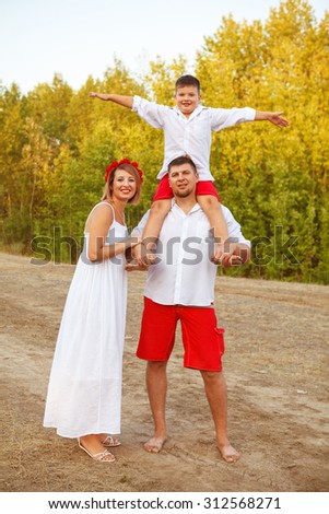 mom dad and son posing at the park outdoors