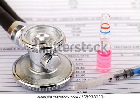 Stethoscope and an ampoule over medical record