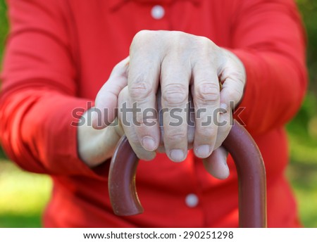 Close up of an elderly hand holding a cane
