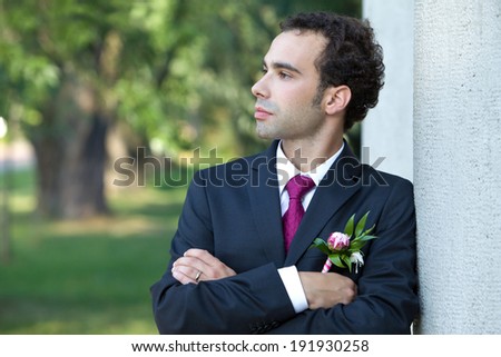 Groom awaiting his bride. Portrait of the groom with a buttonhole of the peony flower.