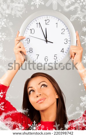 beautiful young woman holding clock wich are displaying 5 minutes to midnight