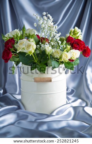 roses in a bucket on a background of satin