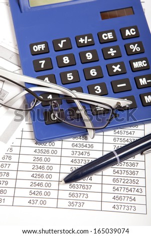 Glasses and calculator on paper table with finance report