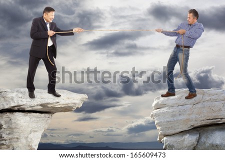 Two adult businessman pull the rope