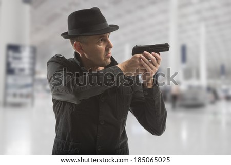 secret service man with gun on grey background