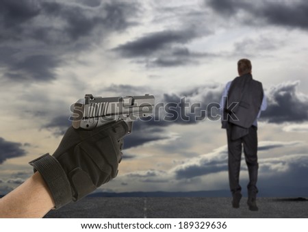 Man\'s hand holding a pointing gun with a finger on the trigger