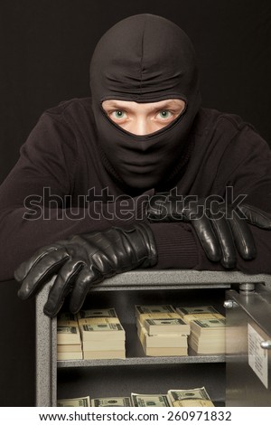 Thief burglar stealing dollar money during home safe code breaking