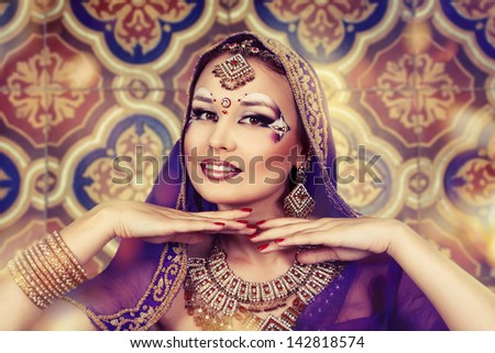Shot of an oriental woman in a traditional costume, smiling, hands under the chin