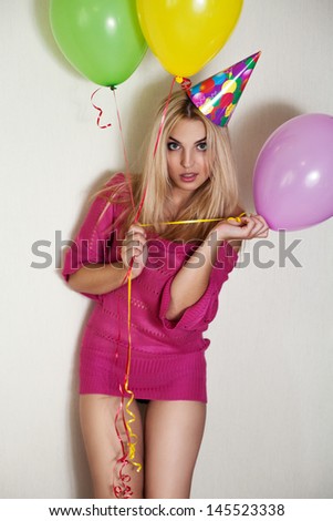 Fashion portrait of sexy and beautiful young women posing with ballons and birthday hat