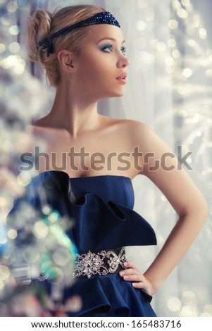 Luxury fashion portrait of girl in blue dress, winter background