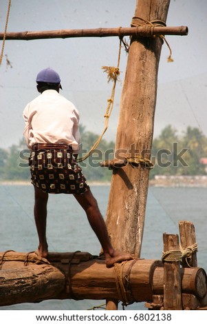 Man working on a wooden fishing platform, Kerala, India
