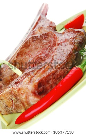 savory : roasted beef spare rib on green dish with cutlery thyme pepper and tomato isolated over white background