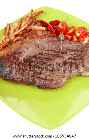 main course : grill beef steak with potato chips and fresh cherry tomato , dry red hot chili peppers on green plate isolated on white background