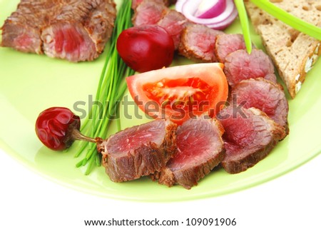 main course : roast red meat slices served on green plate with tomatoes and sprouts isolated on white background