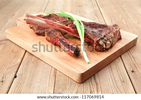 meat savory : roasted beef ribs served with green chives over black table