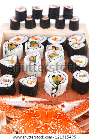 Maki Roll with Deep Fried Vegetables inside . on wooden plate with live crab . isolated over white background . Japanese Cuisine