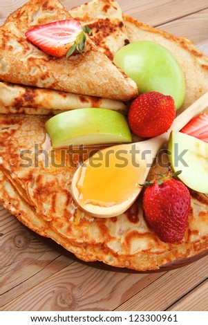 baked food : pancake with honey strawberries and apple on wooden table