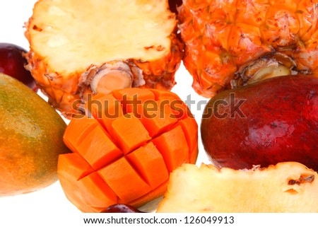 exotic fruit food - a lot of fresh raw tropical fruits include pineapple mango and red plums isolated over white background