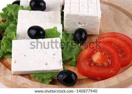 served sliced goat cheese with vegetables on wood