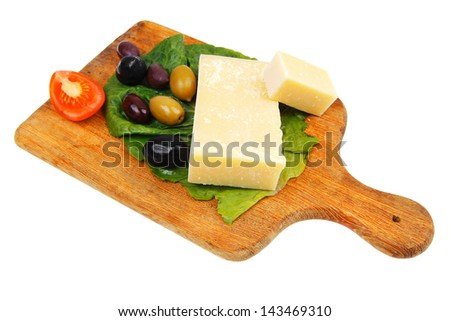 yellow edam cheese on wooden platter with olives and tomato isolated over white background