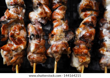 shish kebab on grilling grid over barbecue charcoal