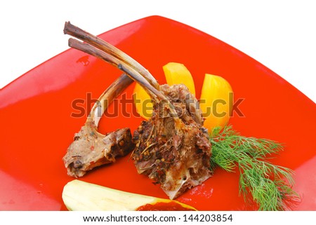 main entree : grilled beef small ribs served with mango fruit and filled avocado on red dish isolated over white background
